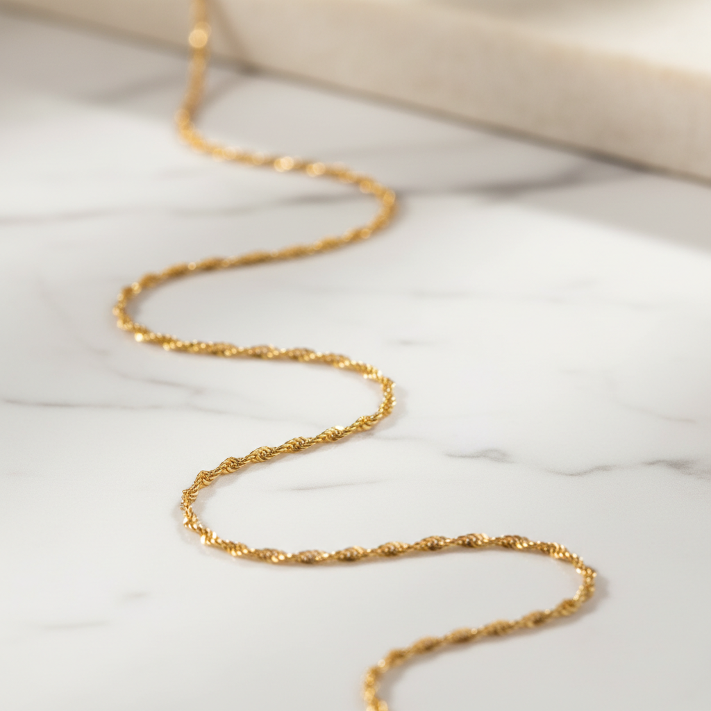 ROVIA 18K Gold Singapore Chain on white marble surface